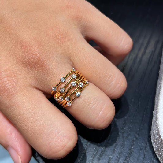 Scattered CZ multi-band gold-plated ring worn on a hand - close-up