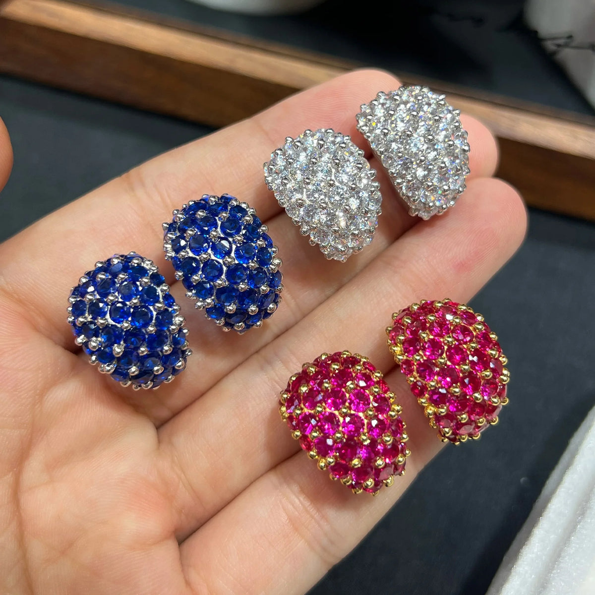 Close-up of red blue and clear round cubic zirconia earrings