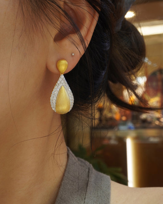 woman wearing elegant brushed gold teardrop CZ earrings