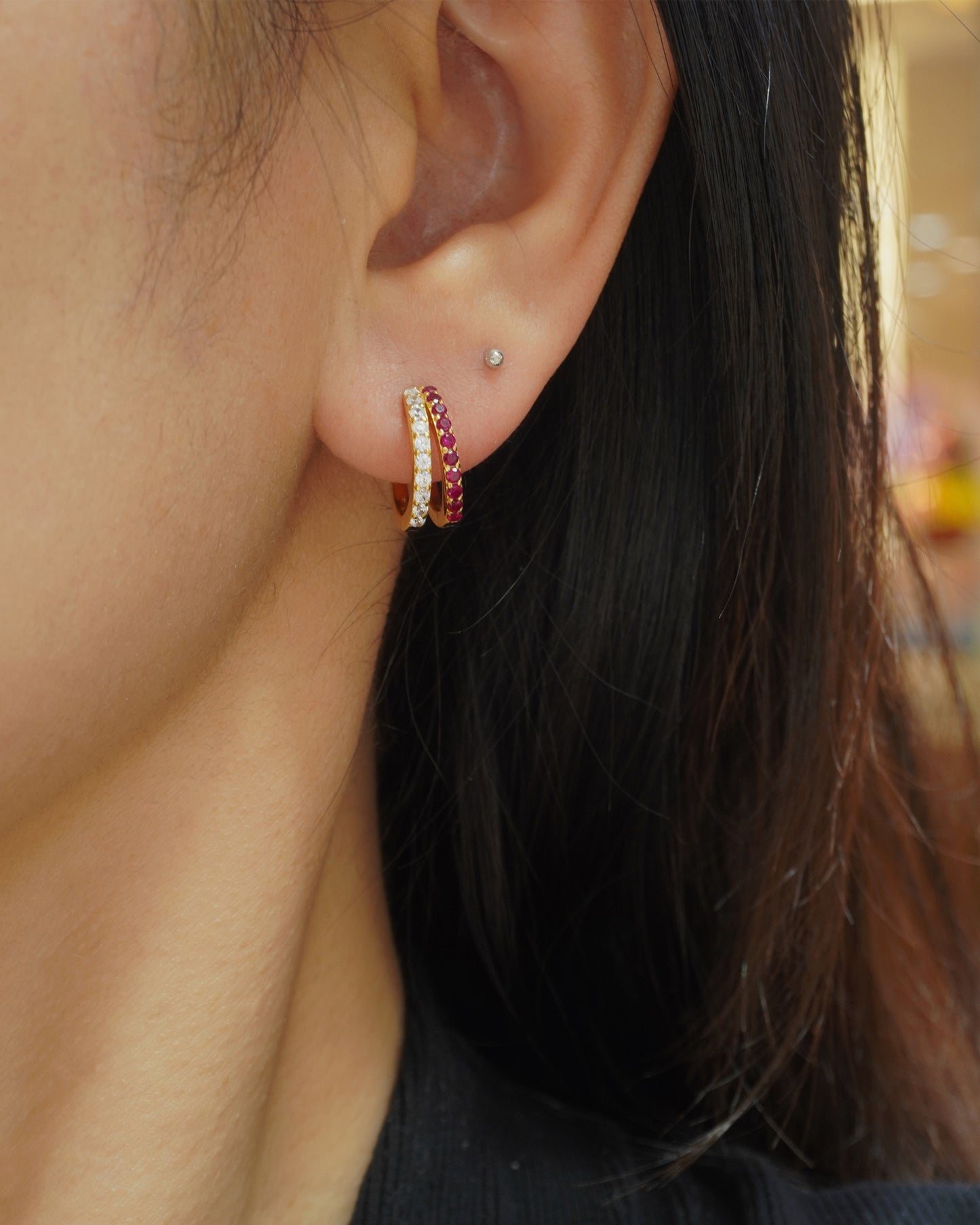 woman wearing elegant ruby and CZ gold huggie hoop earrings