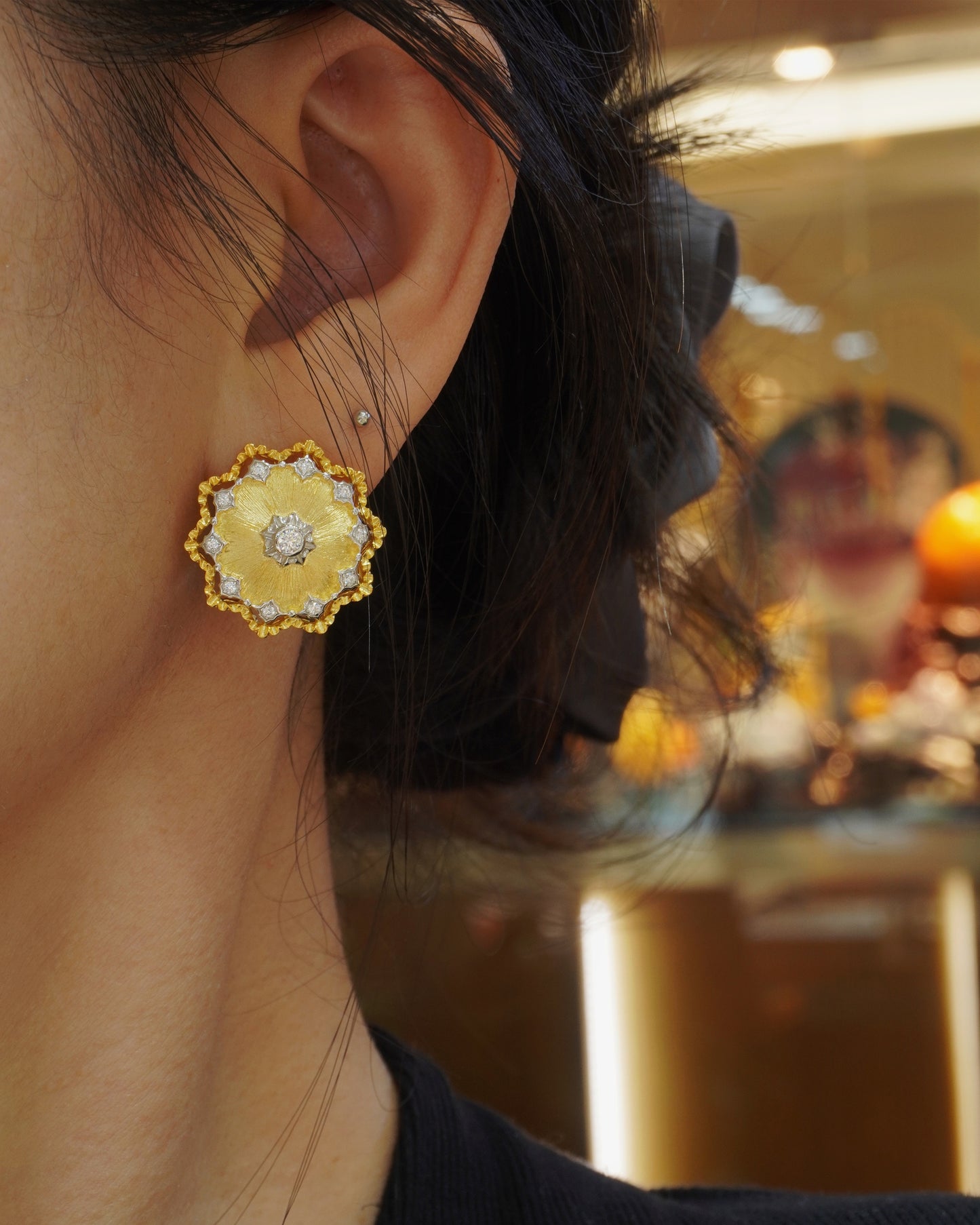 woman wearing elegant vintage floral gold stud earrings with CZ halo detail