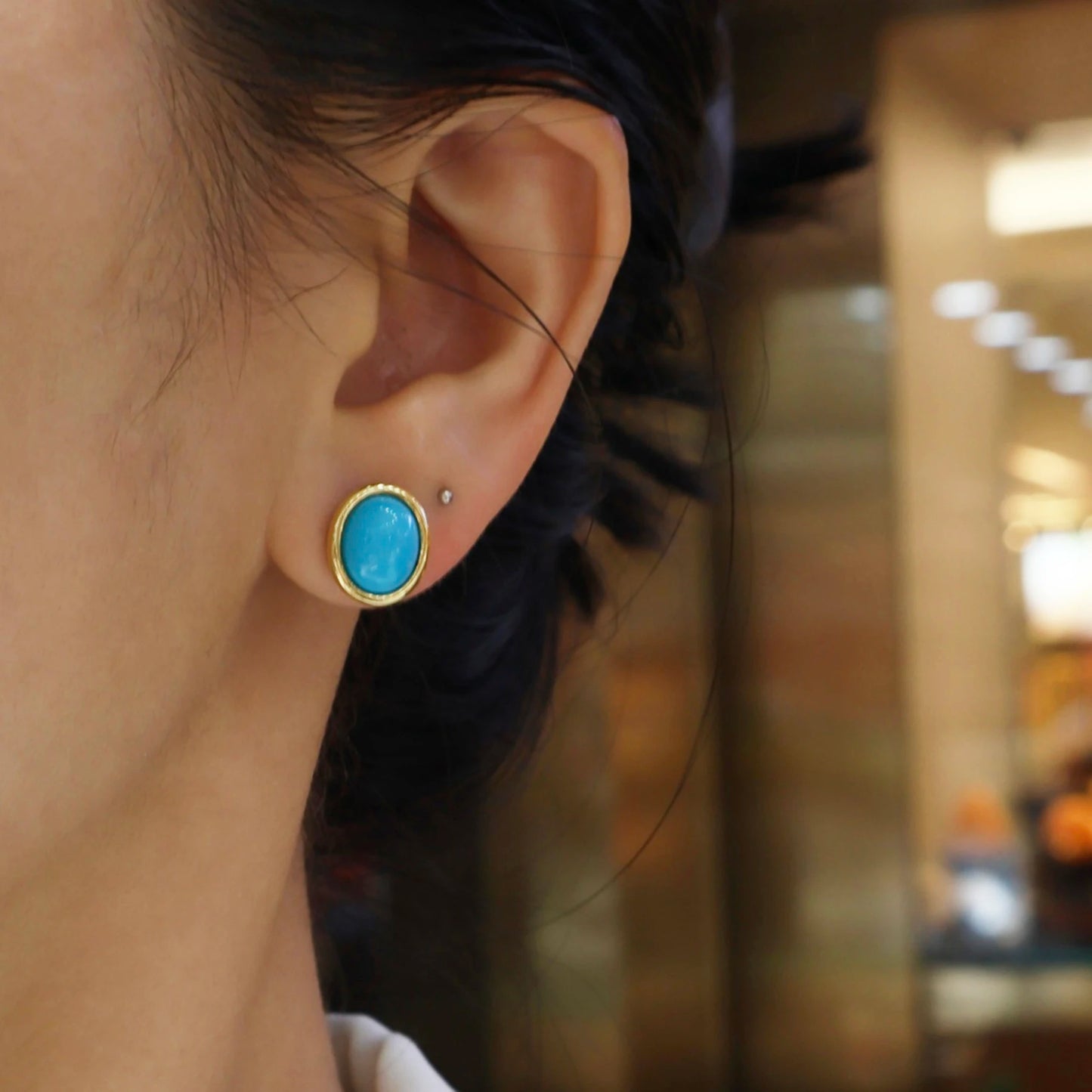 woman wearing turquoise blue cabochon gold plated stud earrings