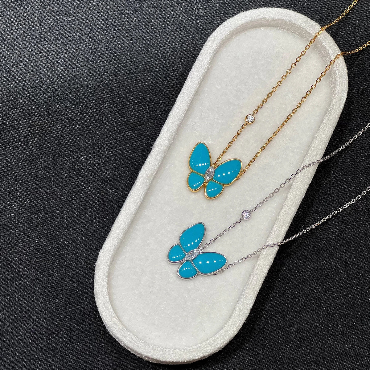 Blue and silver created turquoise butterfly necklaces on a white background