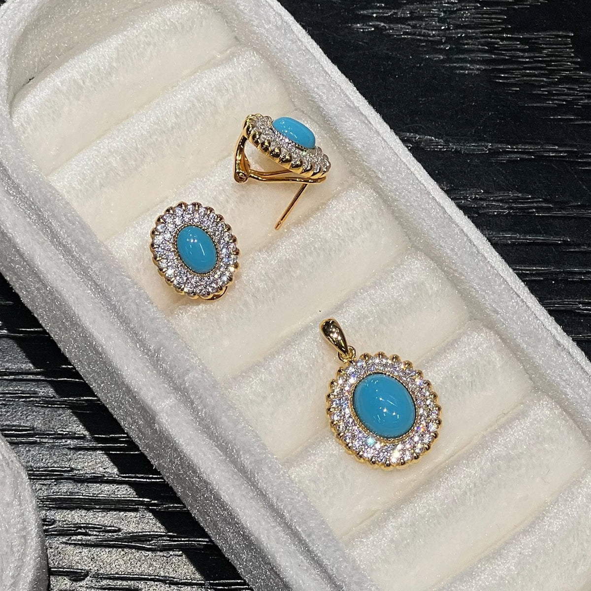 Side view of pierced created turquoise earrings and matching double halo pendant