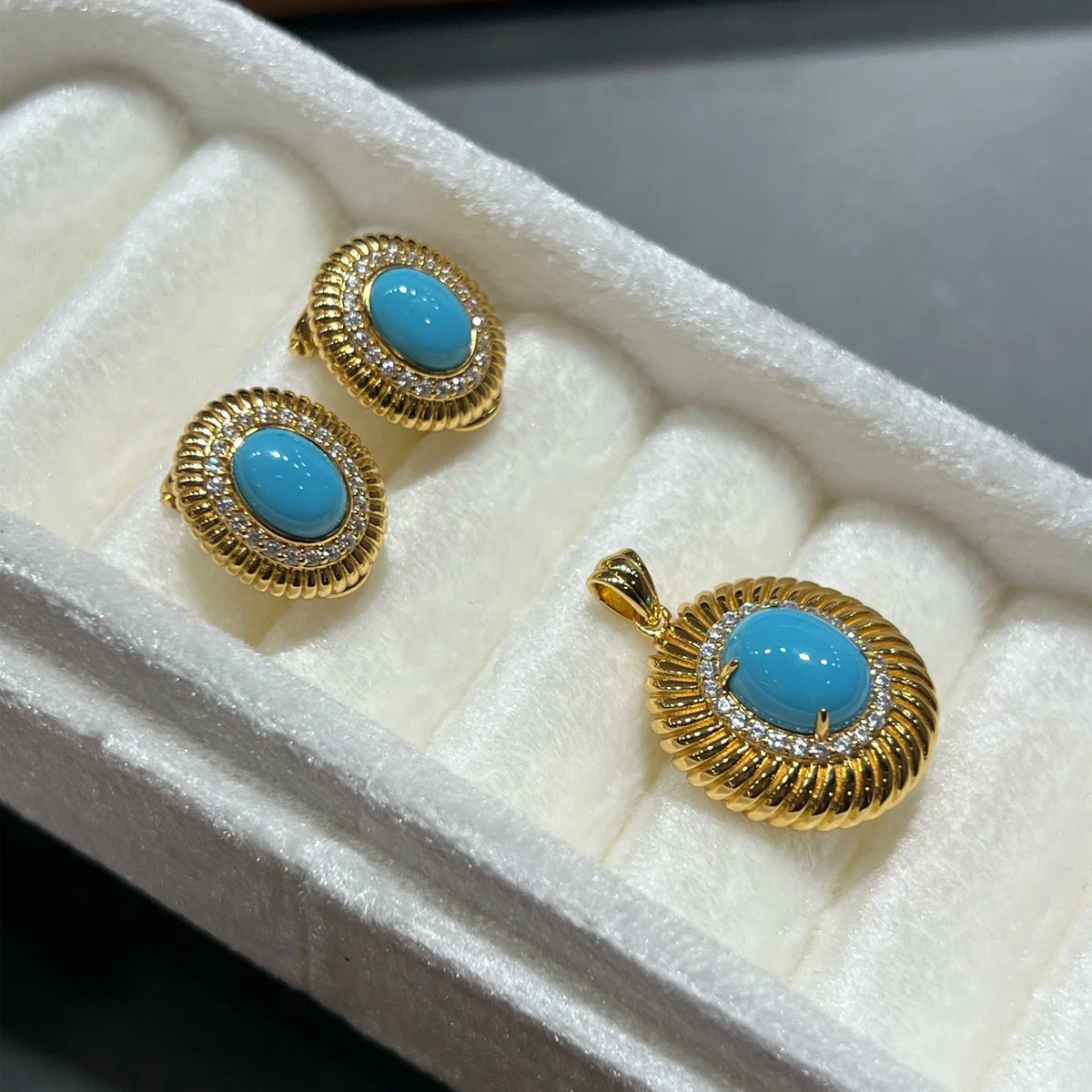 Coordinated oval created turquoise earrings and pendant with textured gold tone frames