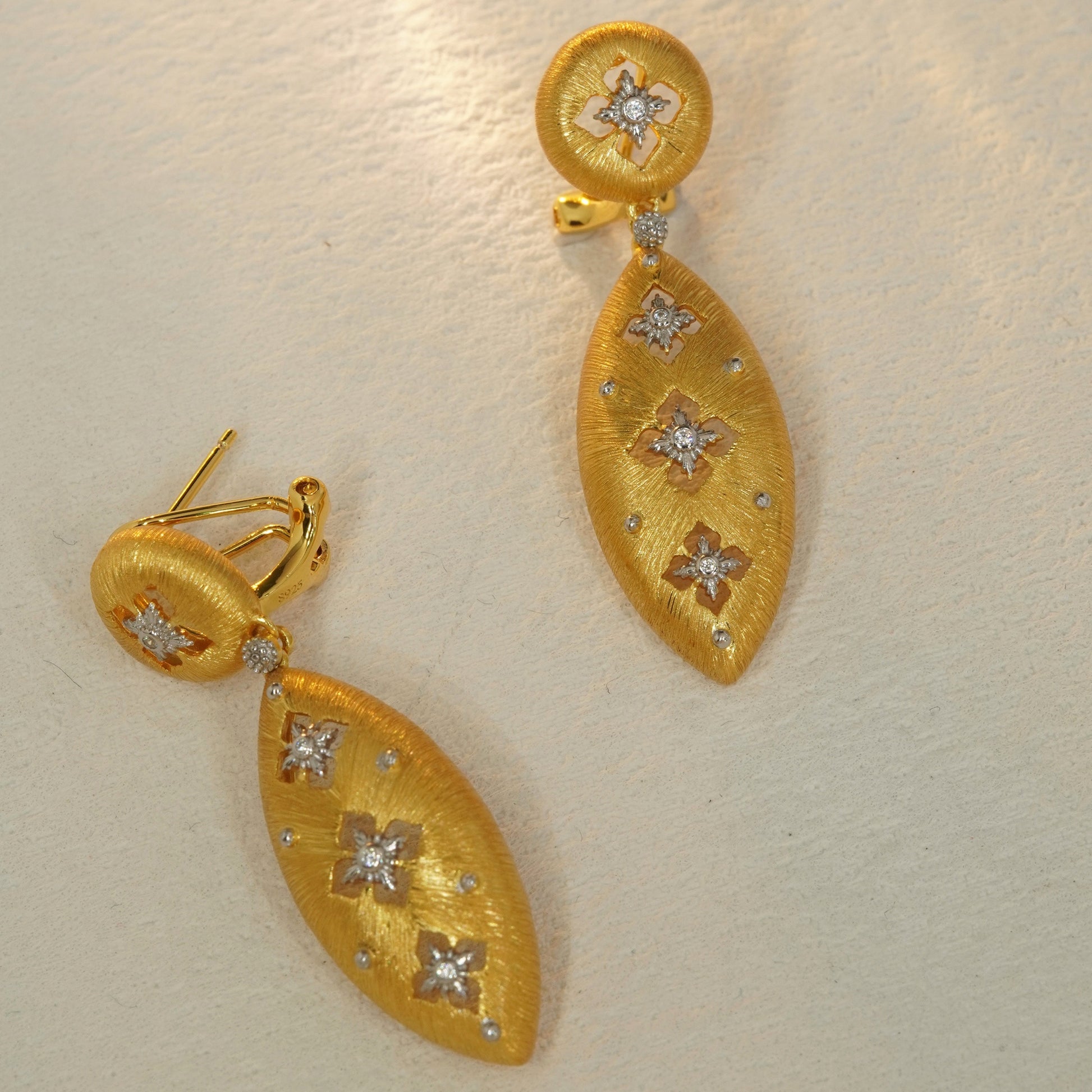 Brushed gold teardrop drop earrings featuring floral cut out design and cubic zirconia details