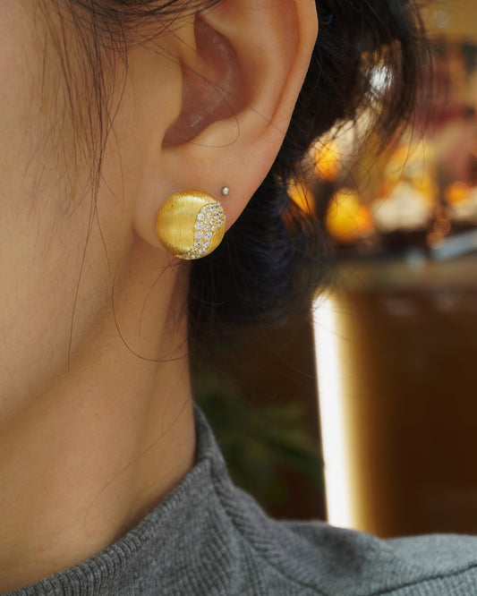woman wearing minimalist brushed gold CZ stud earrings with elegant modern style