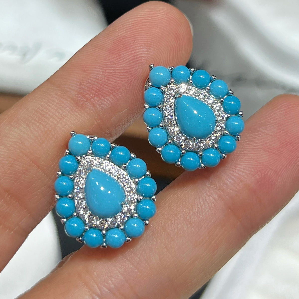 Turquoise Teardrop Halo Stud Earrings Handheld View - 925 Sterling Silver