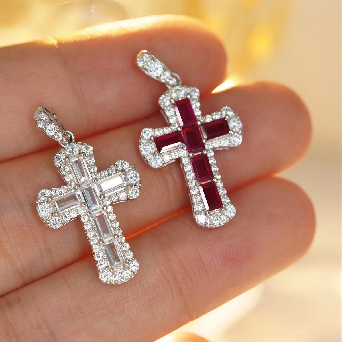 Hand-held view of red and white baguette-cut cubic zirconia cross pendants