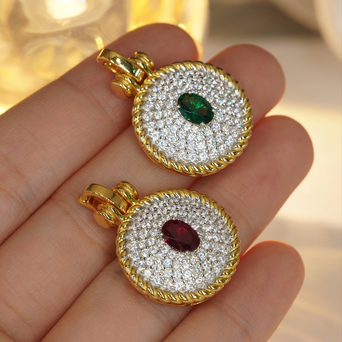 Red and green oval CZ pavé pendants shown in hand