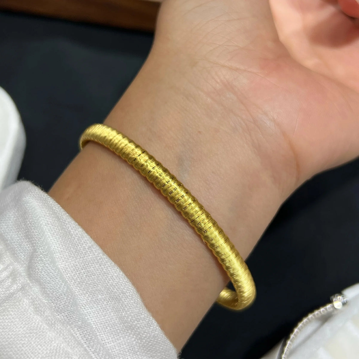 Gold brushed open cuff bracelet worn on the wrist