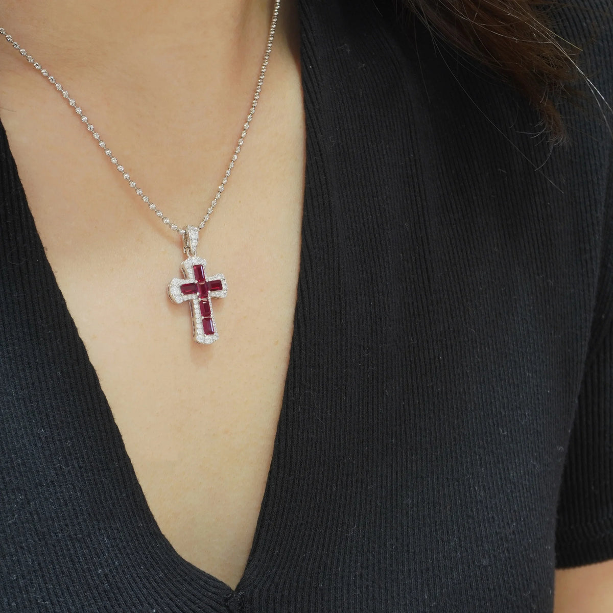 Model wearing the red baguette-cut cubic zirconia cross pendant