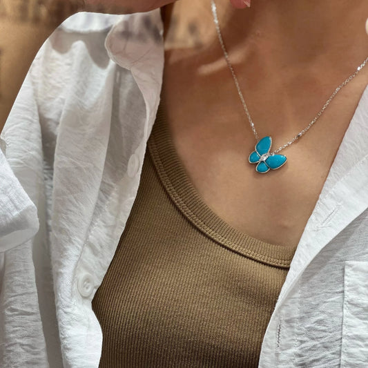 Silver created turquoise butterfly necklace worn by a model