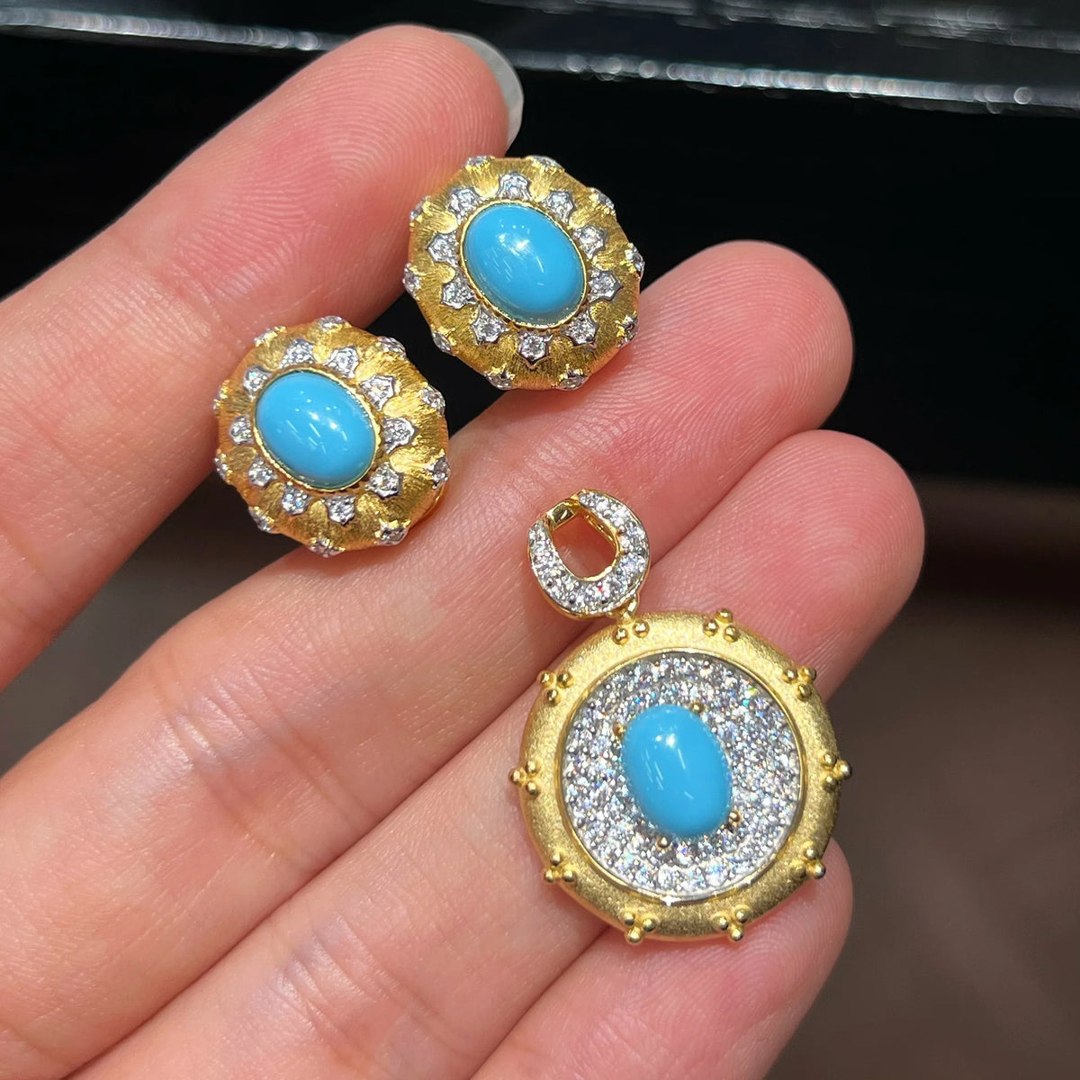 Hand-held view of created turquoise earrings and pendant; chain not included