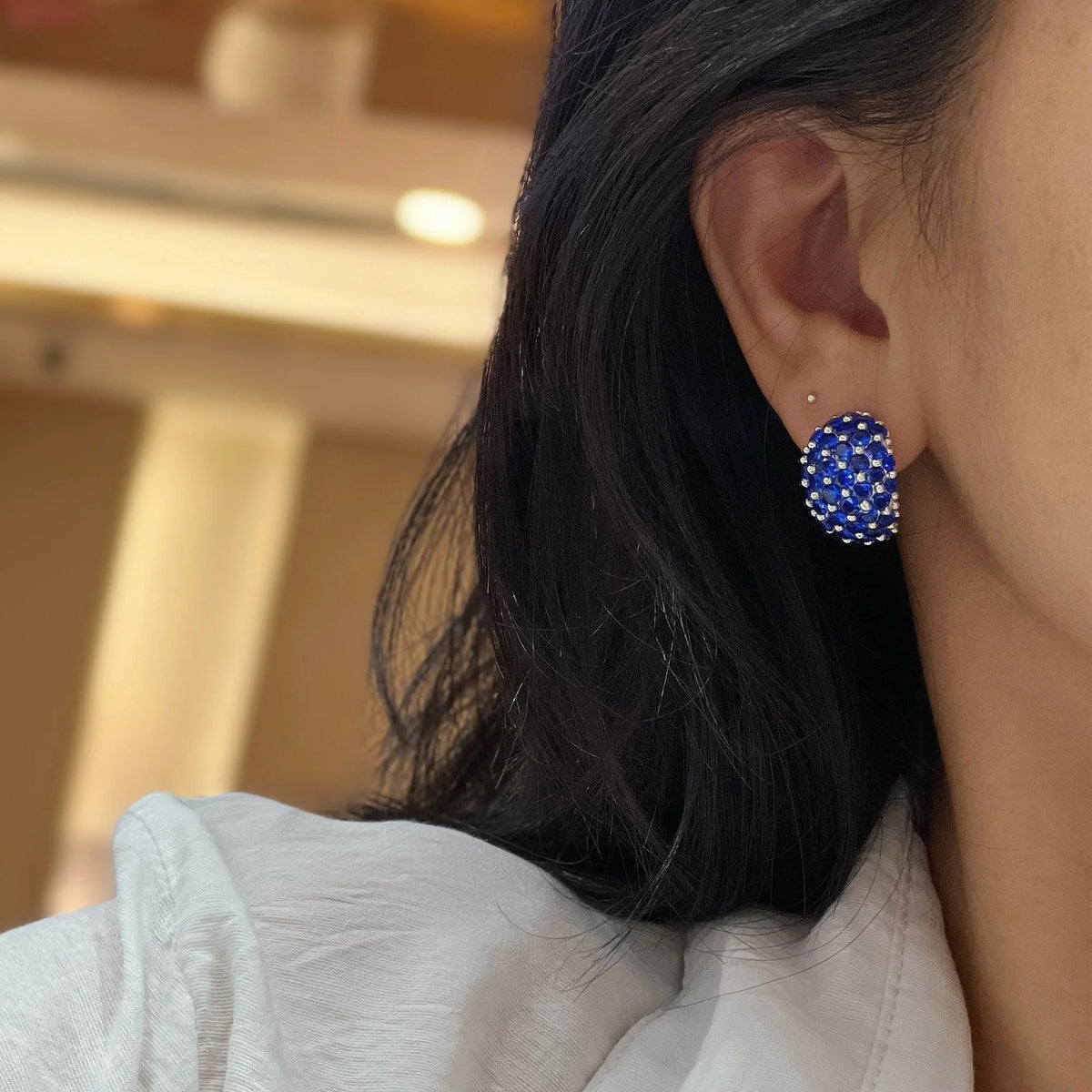 Blue sculpted wide clip-on earrings shown in profile