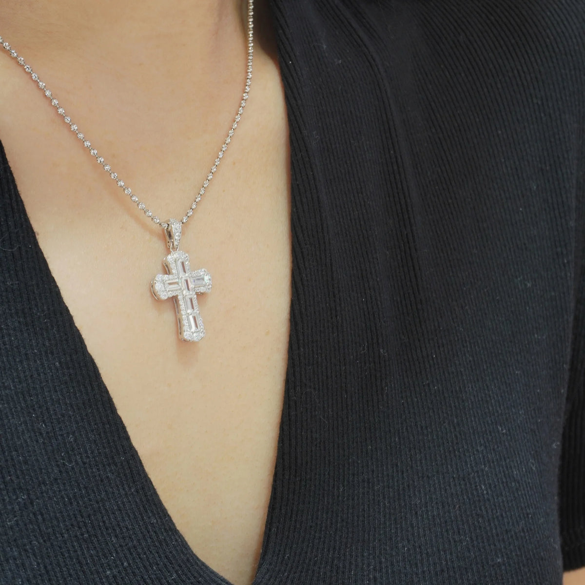 Model wearing the white baguette-cut cubic zirconia cross pendant