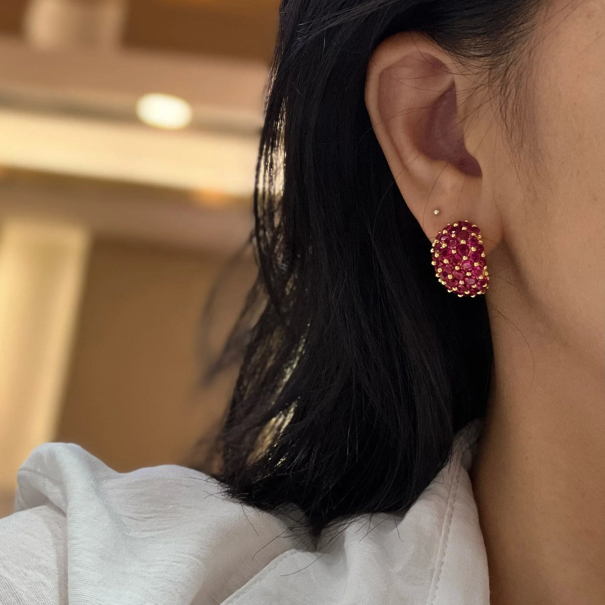 Red sculpted wide clip-on earrings shown in profile