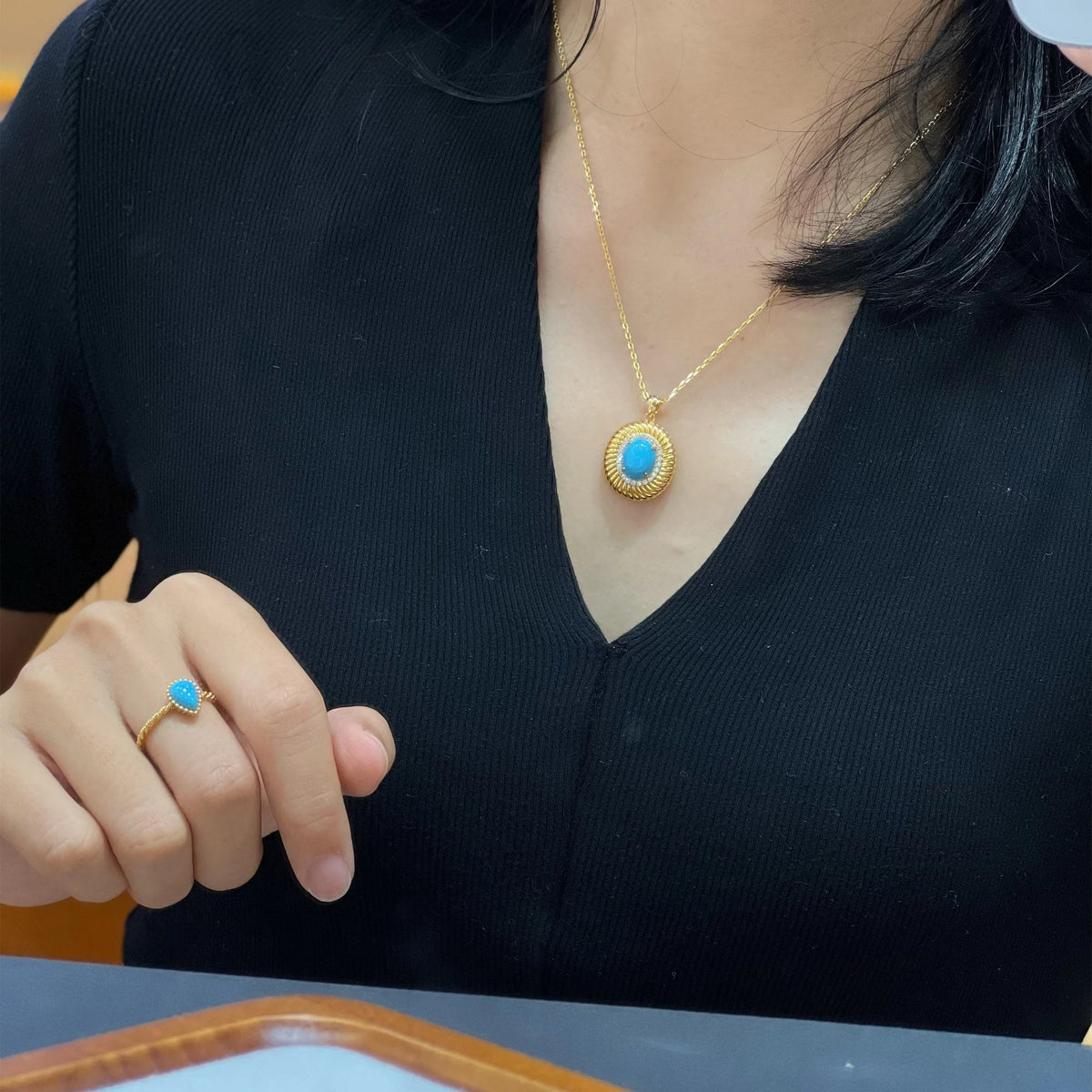 Model styling the turquoise pendant; chain and ring shown are not included