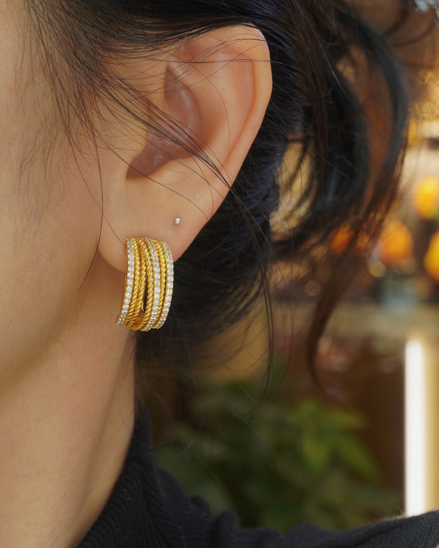 Woman wearing elegant 18K gold plated huggie hoop earrings