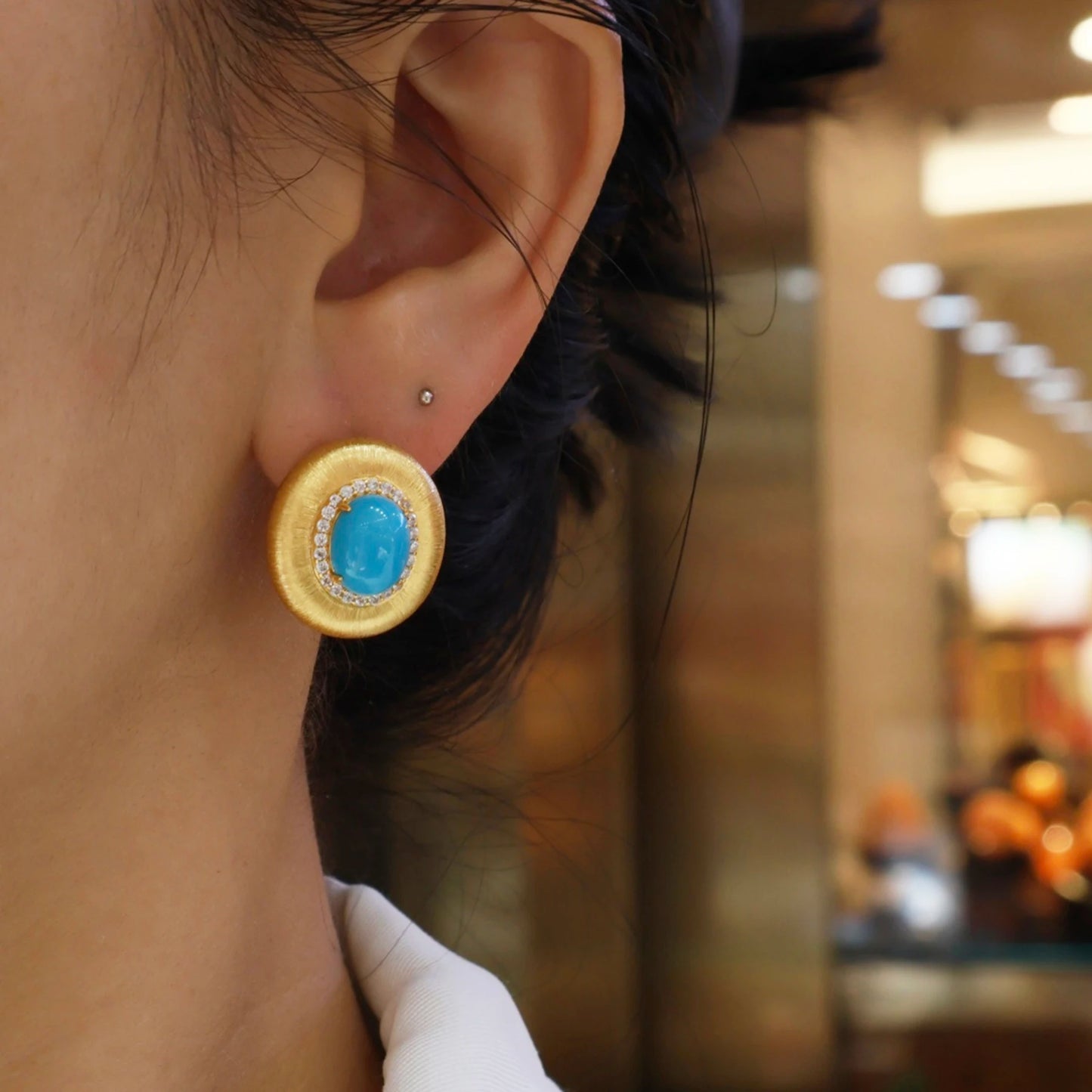 woman wearing minimalist gold turquoise halo stud earrings