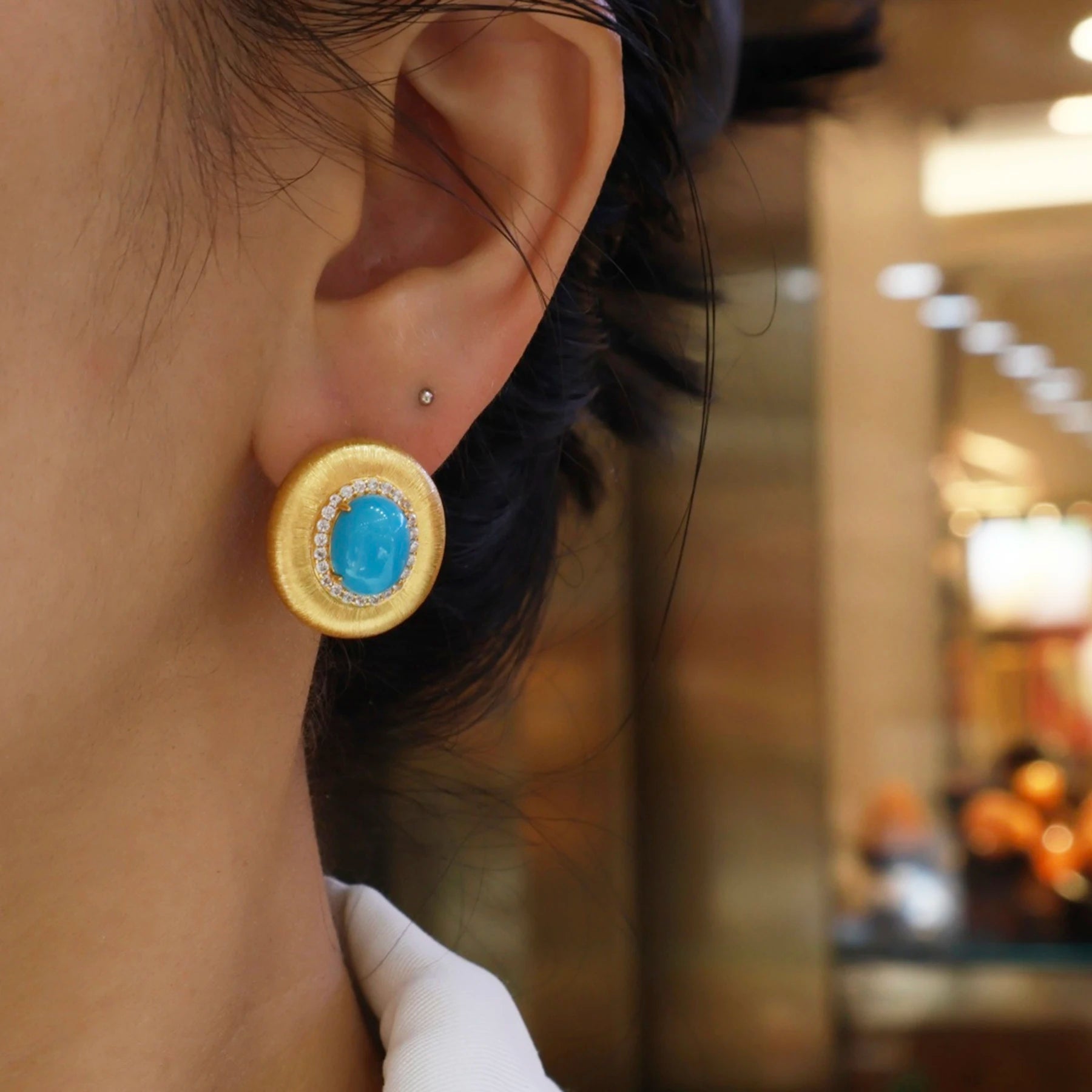 woman wearing minimalist gold turquoise halo stud earrings