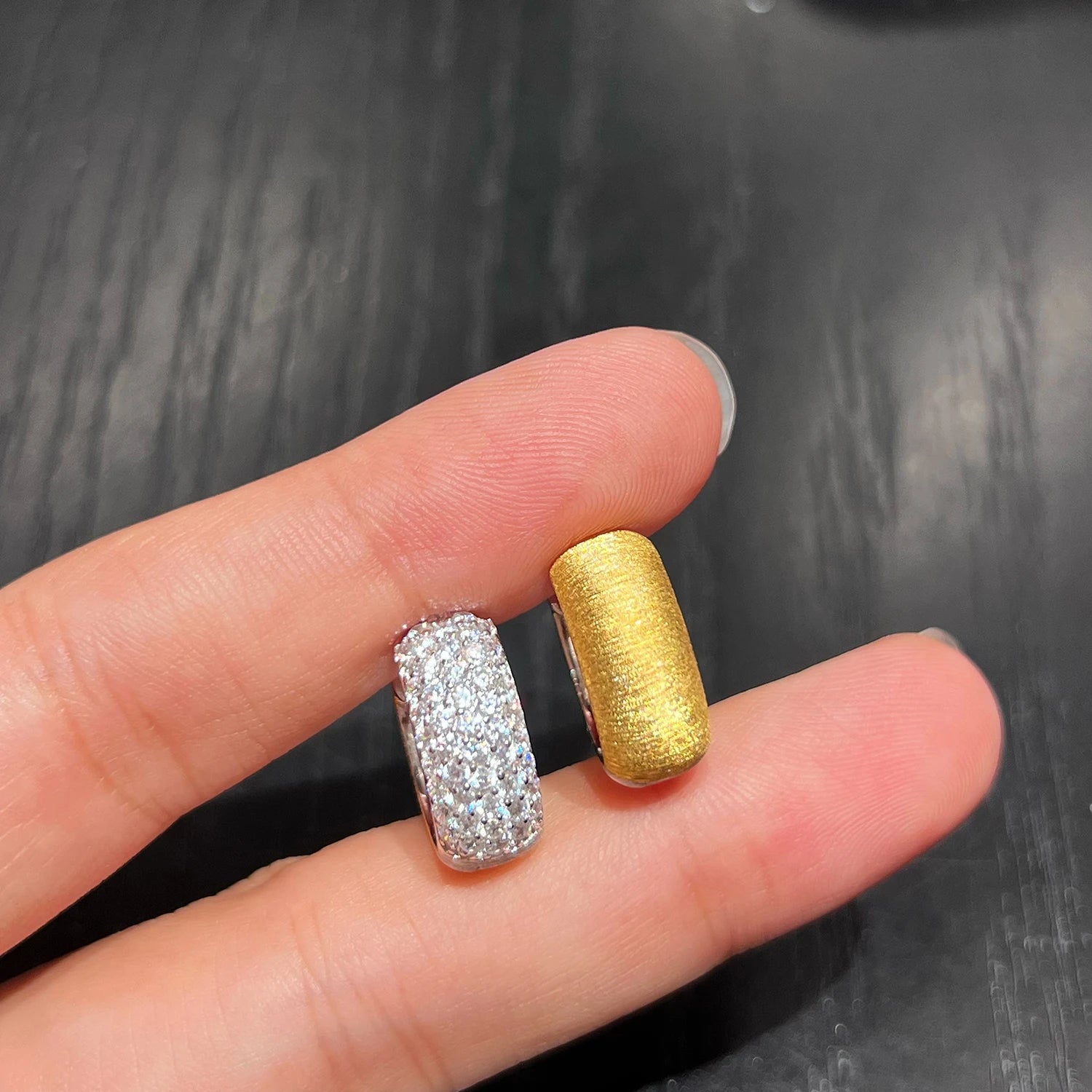 Close up view of 18K gold plated sterling silver huggie earrings with CZ stones
