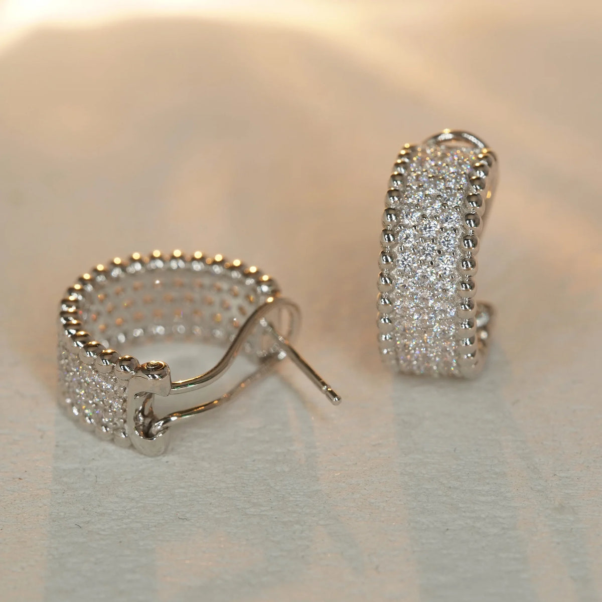 Silver clear CZ beaded-edge hoop earrings, front and closure view