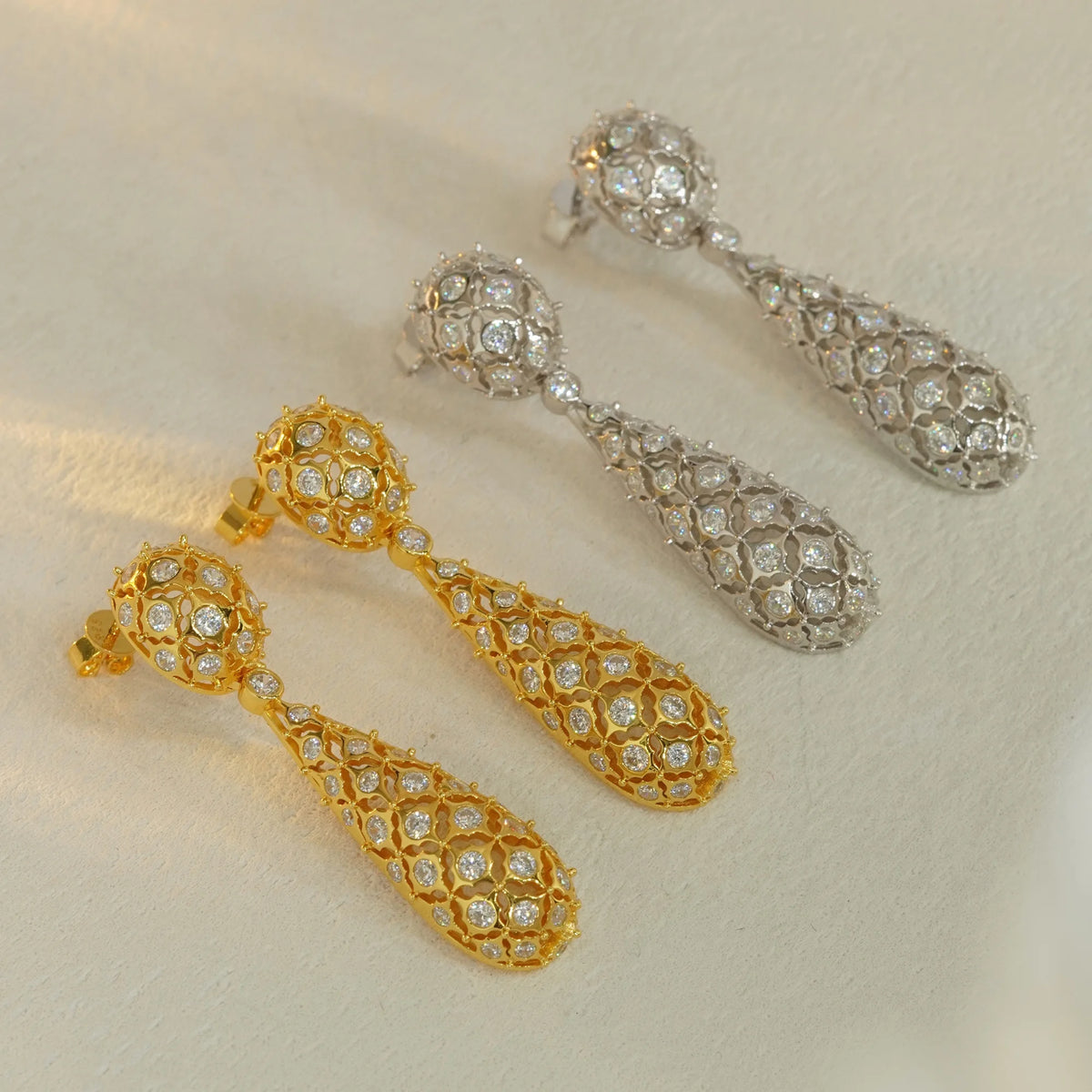 Gold and silver openwork floral pavé CZ drop earrings, angled view