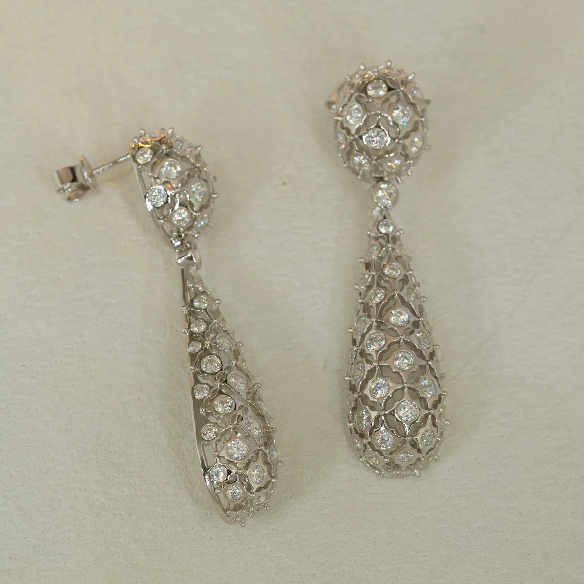 Silver openwork floral pavé CZ drop earrings, front and side view