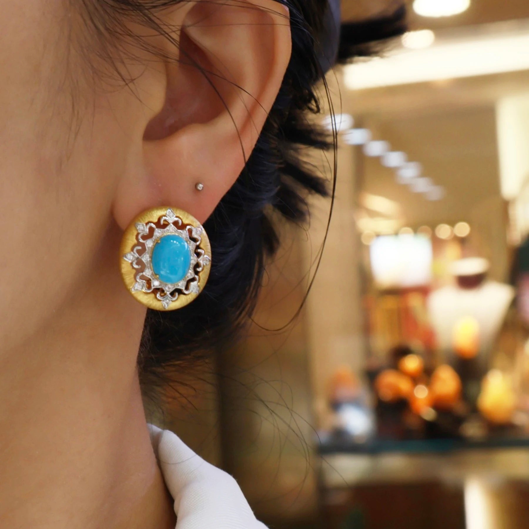 woman wearing vintage turquoise halo stud earrings with gold finish