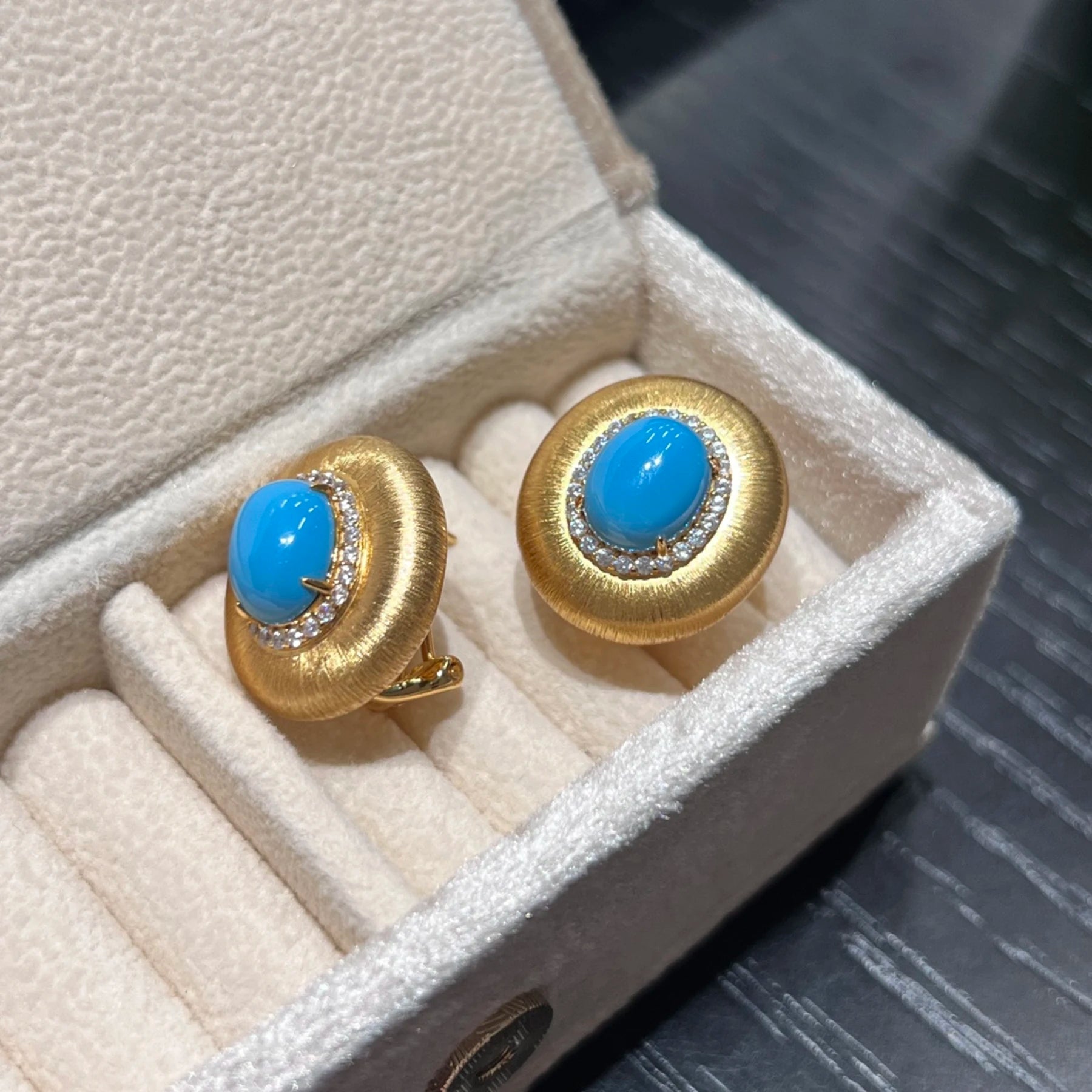 side view of blue created turquoise earrings with 18k gold plated setting